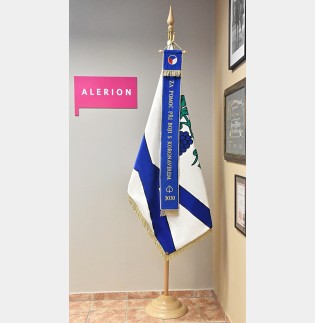 Vyšívaná stuha modrá s děkovným textem „Za pomoc při boji“ vyvěšena na slavnostní obecní vlajce